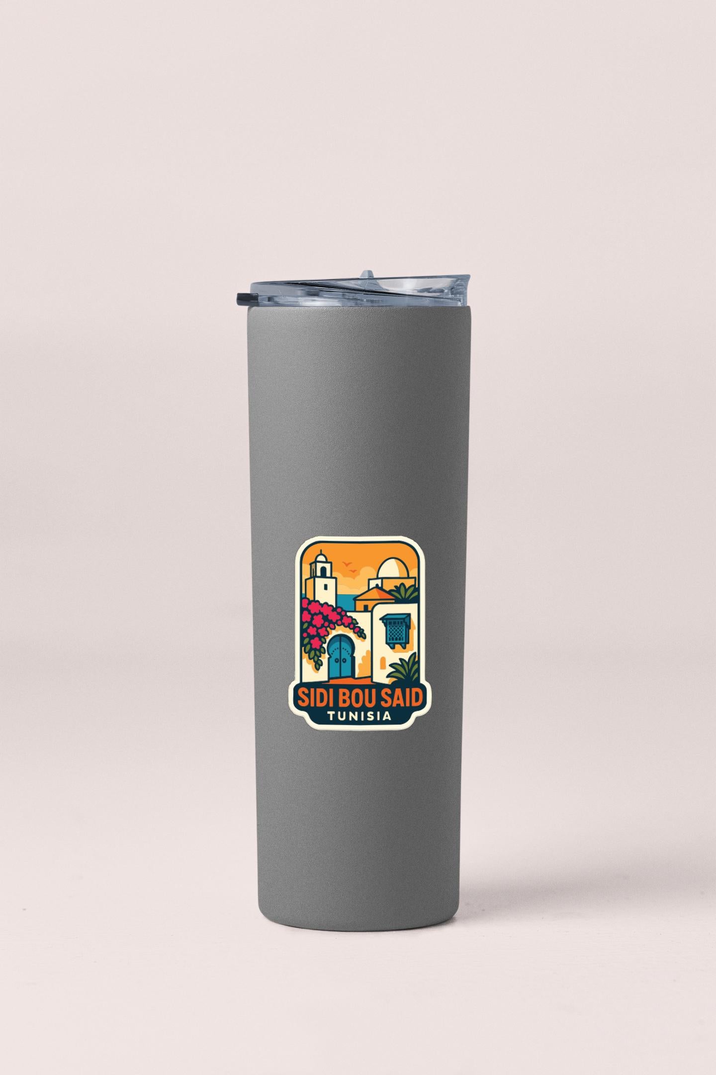 A gray insulated tumbler with a sticker depicting a colorful illustration of a building and the text "SIDI BOU SAID TUNISIA".