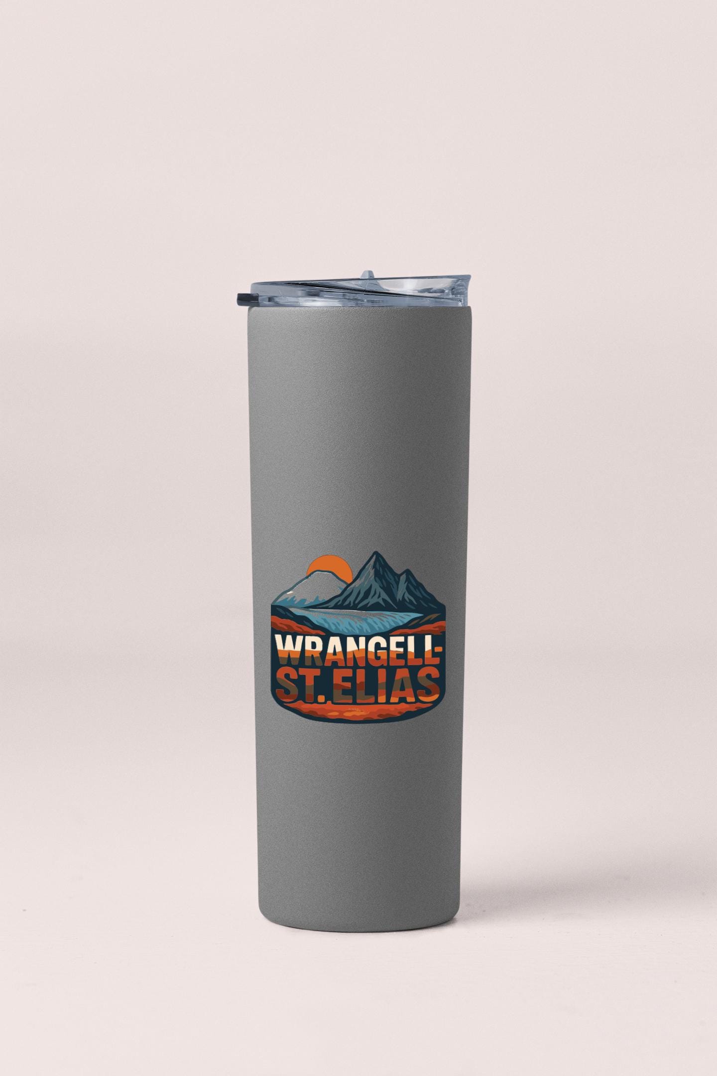 A gray tumbler with a logo featuring mountains and a sunset.