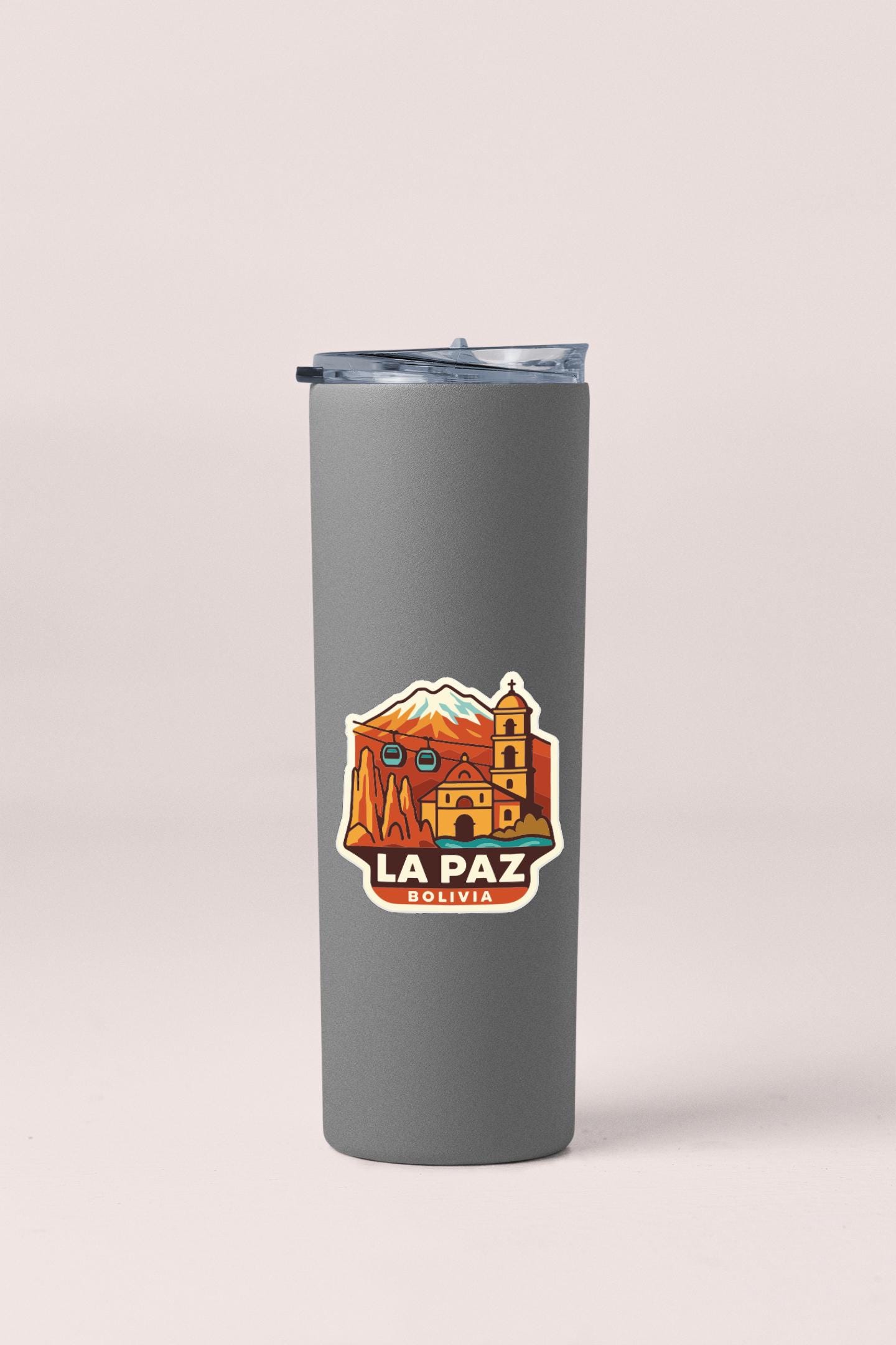 A gray insulated tumbler with a sticker depicting the city of La Paz, Bolivia.