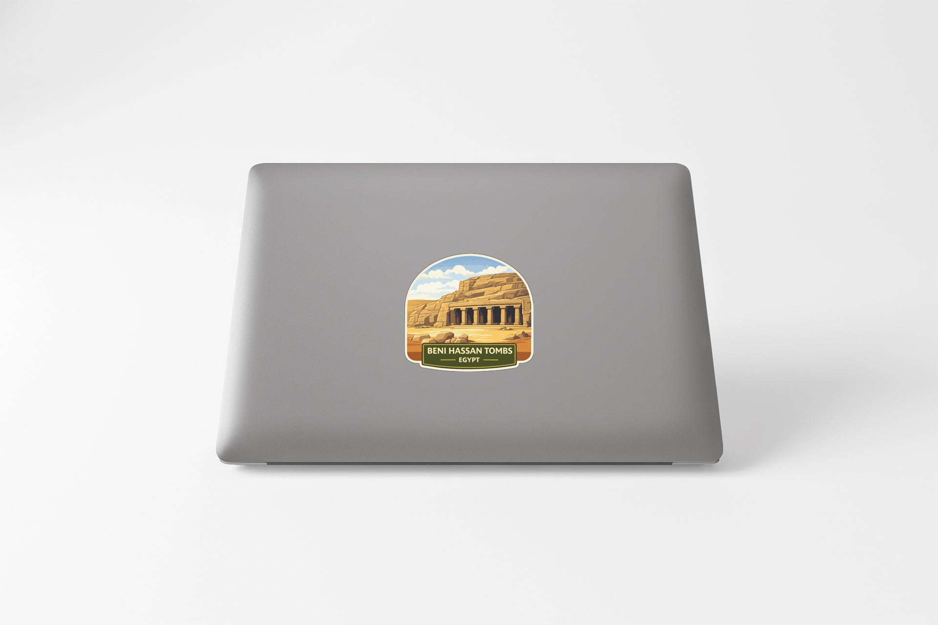 a sticker on the back of a laptop, depicting a desert landscape with a temple in the background.