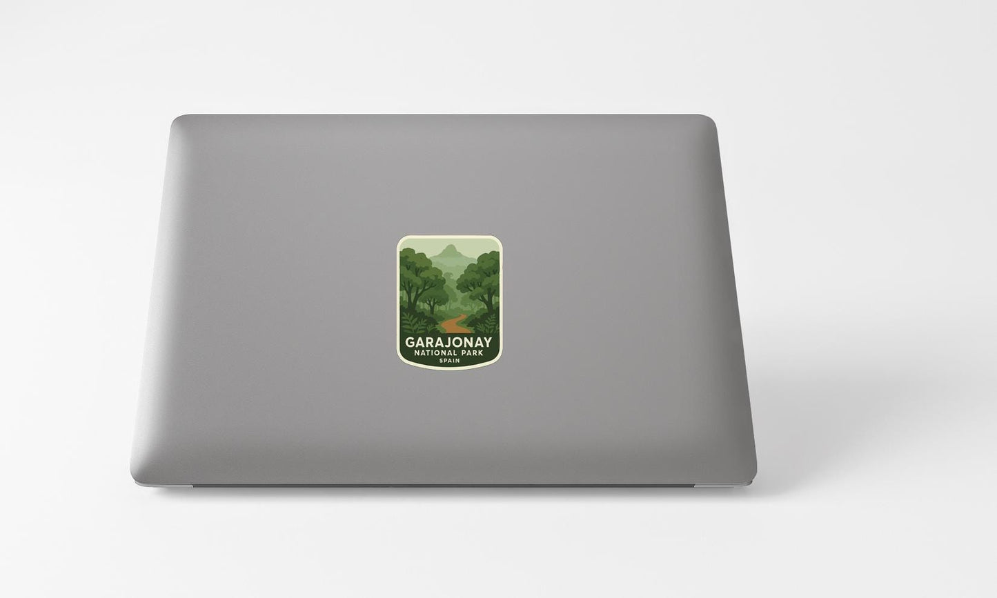 A sticker with a green landscape and mountains on a grey laptop.