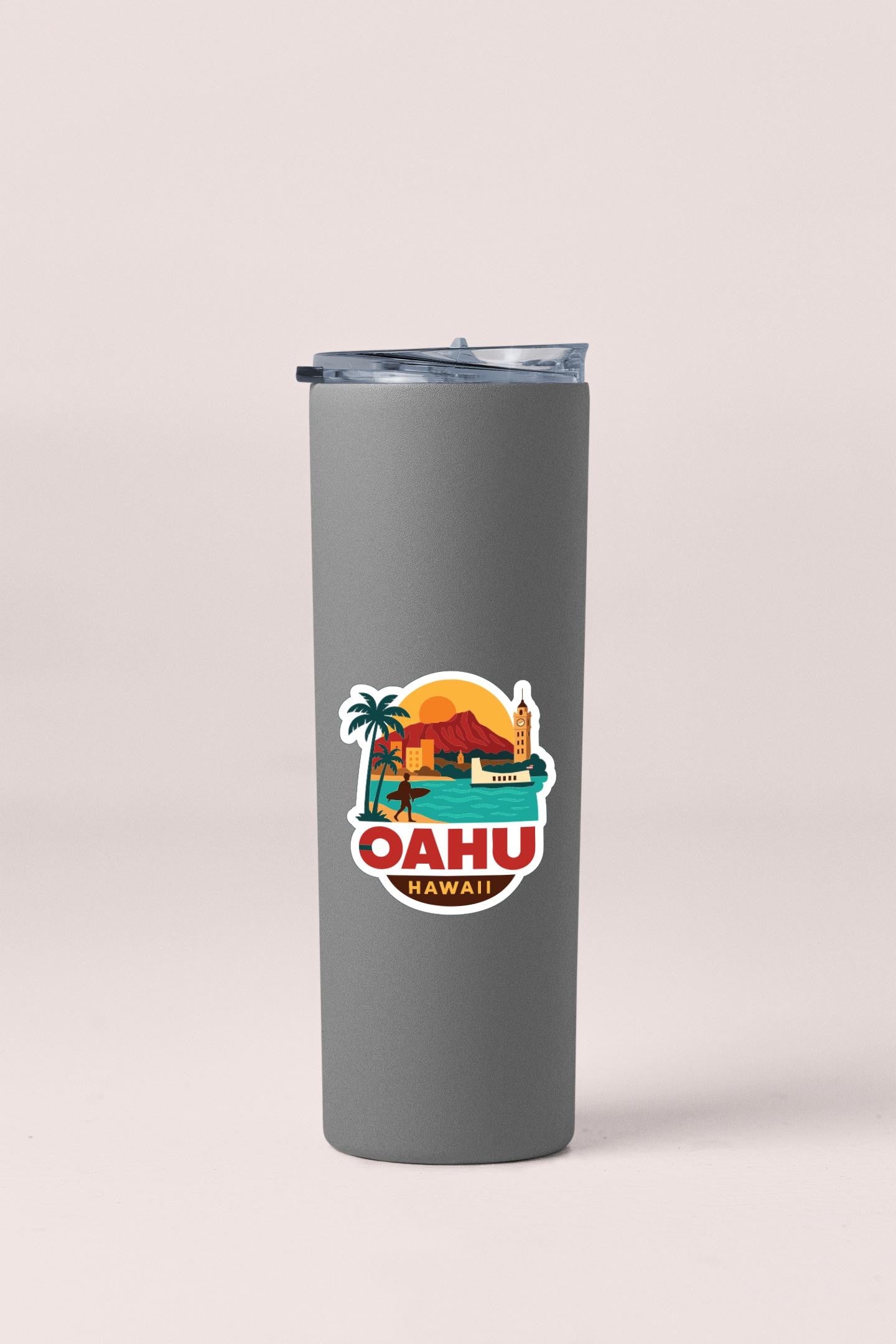 A gray insulated tumbler with a sticker depicting a tropical island and palm trees, along with the text "Oahu Hawaii".