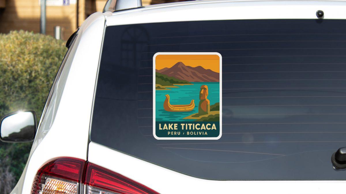 A sticker on the rear window of a white car, depicting a scenic landscape with mountains, a lake, and a boat.