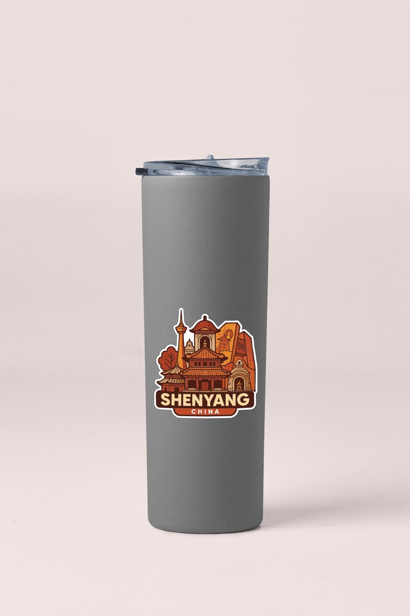 A gray insulated tumbler with a sticker depicting the skyline of Shenyang, China.
