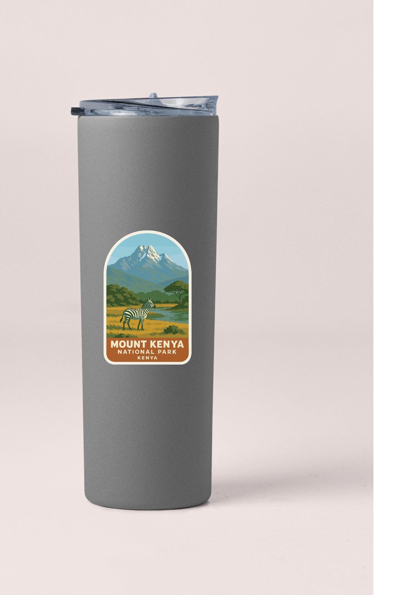 A gray tumbler with a label that features a mountain landscape and a zebra.