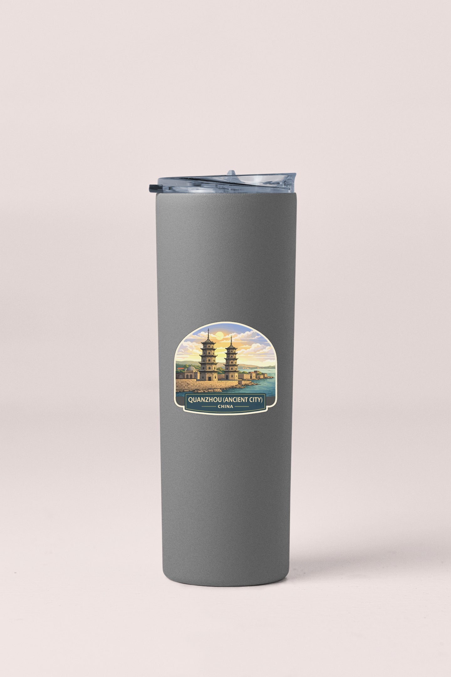 A gray tumbler with a label featuring an illustration of a temple and the text "Qingdao Lion City, China".