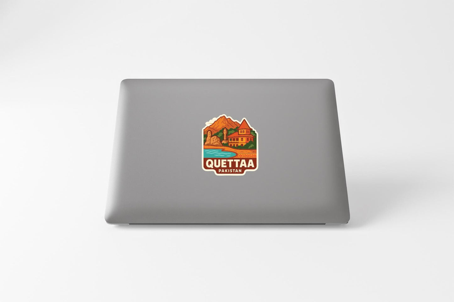 a sticker with a mountain and a house on a laptop.