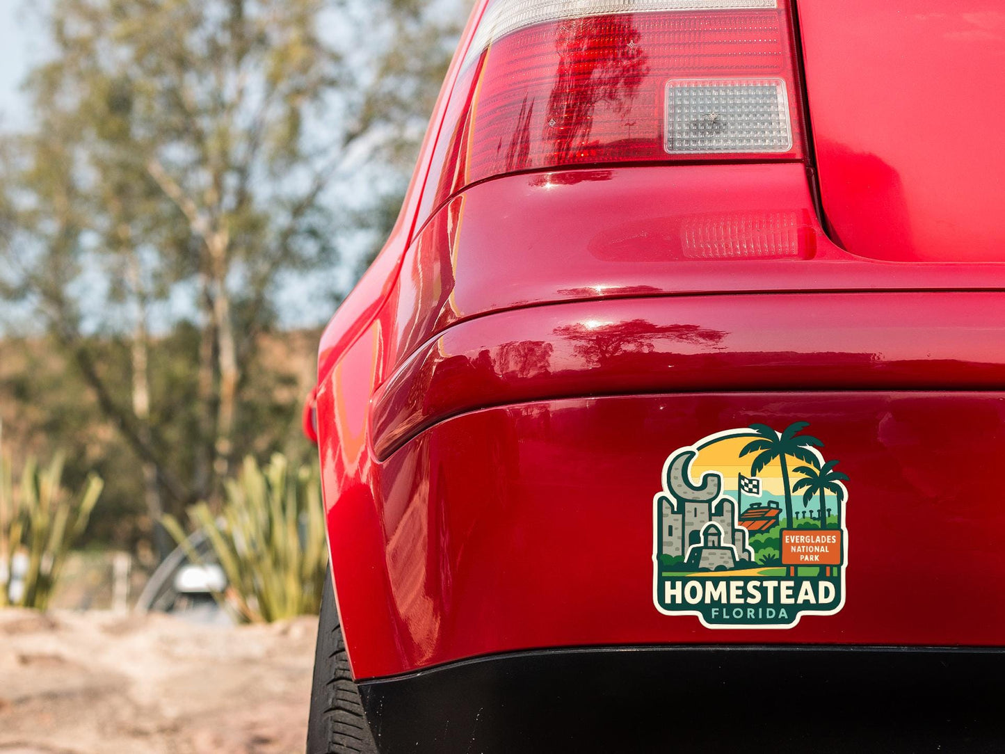 the rear end of a red car with a sticker on the back window that says "HOMESTAD FLORIDA".