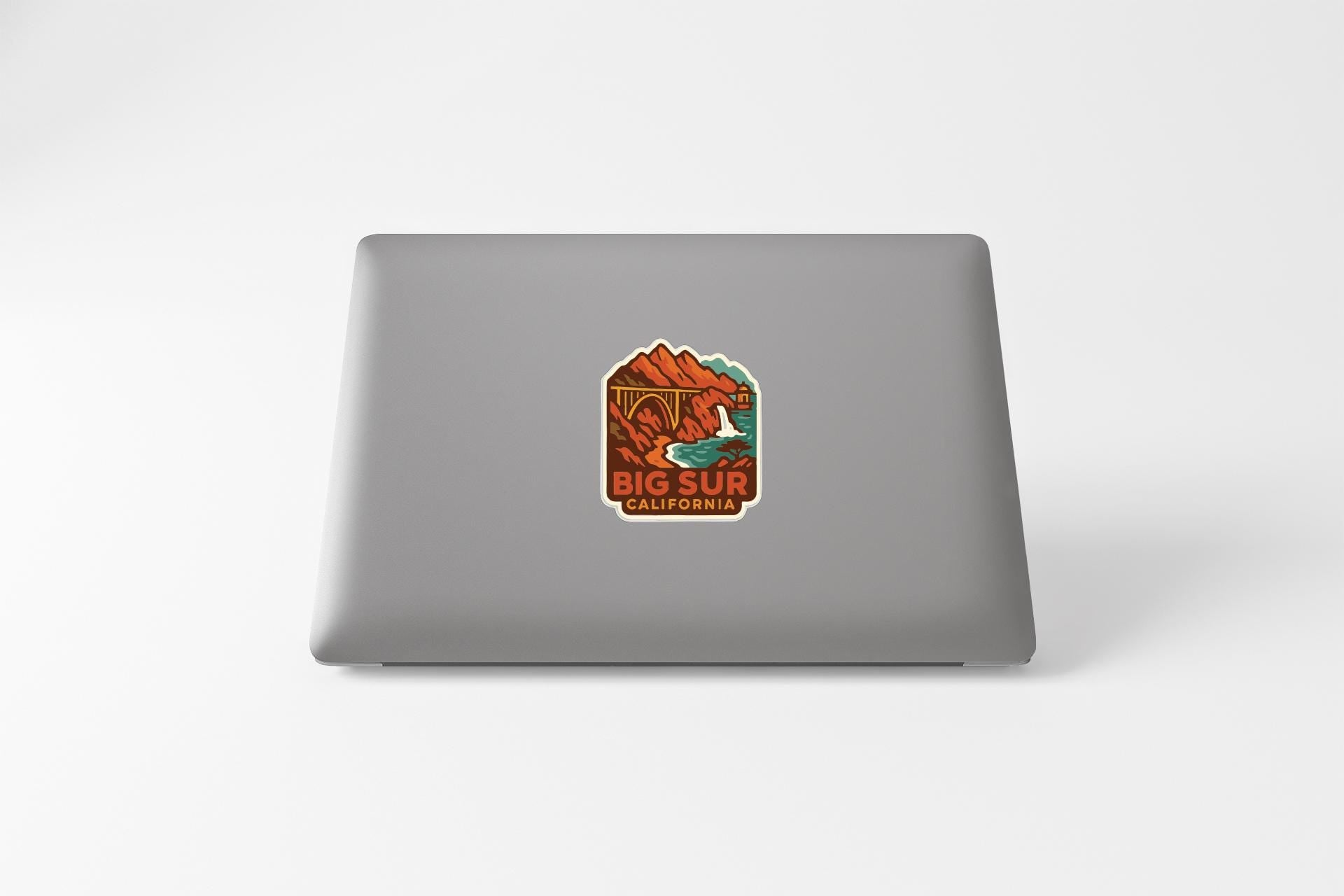 A sticker with a scenic illustration of mountains and water, along with the text "BIG SUR CALIFORNIA".
