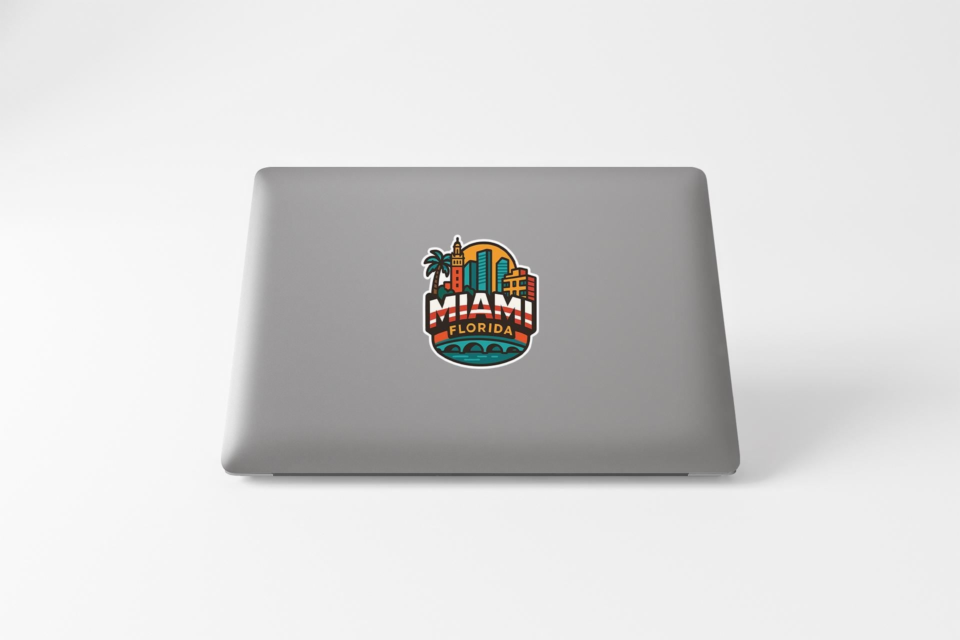 a laptop computer with a sticker of a city