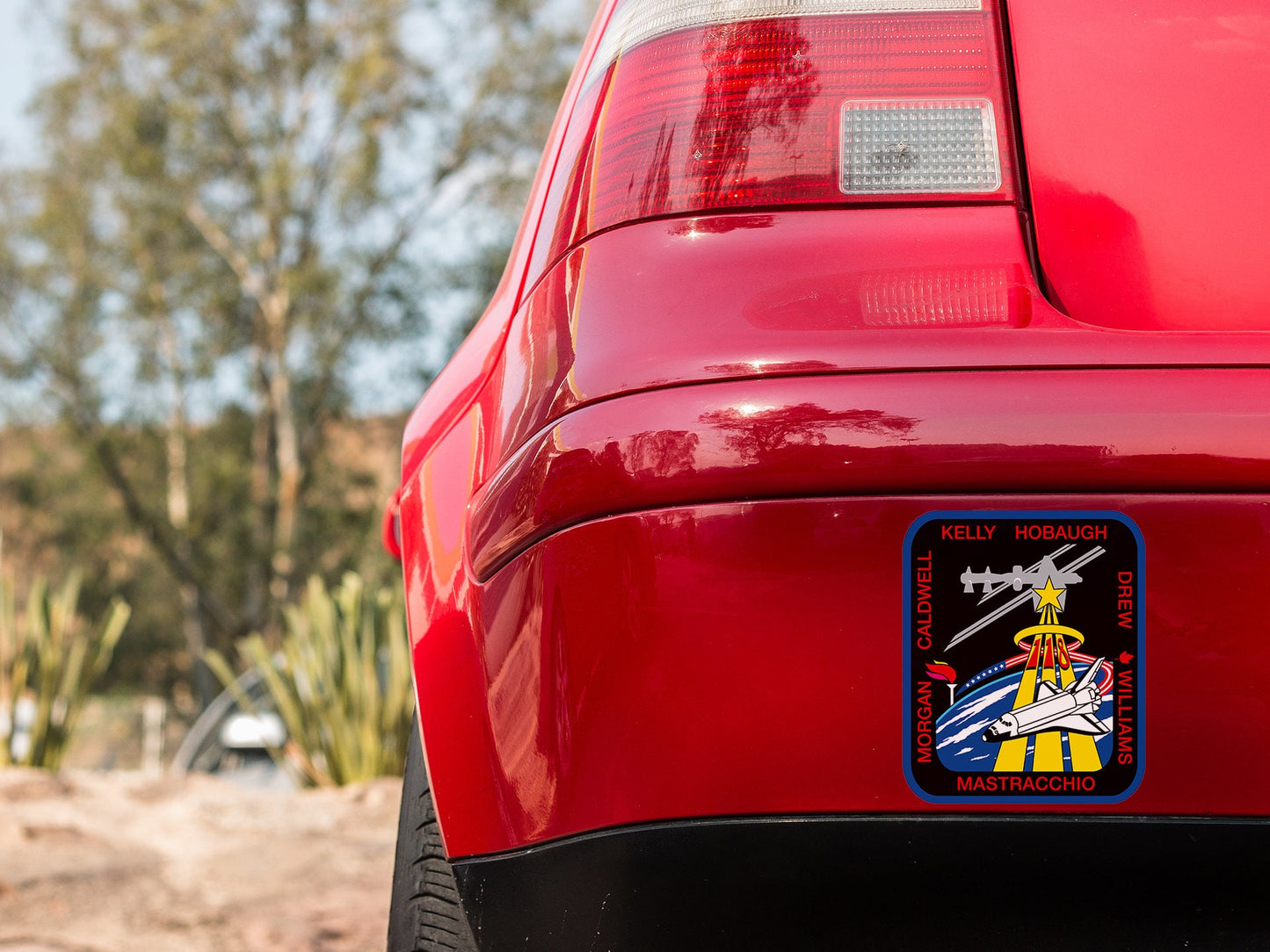 a close up of a red car with a sticker on it