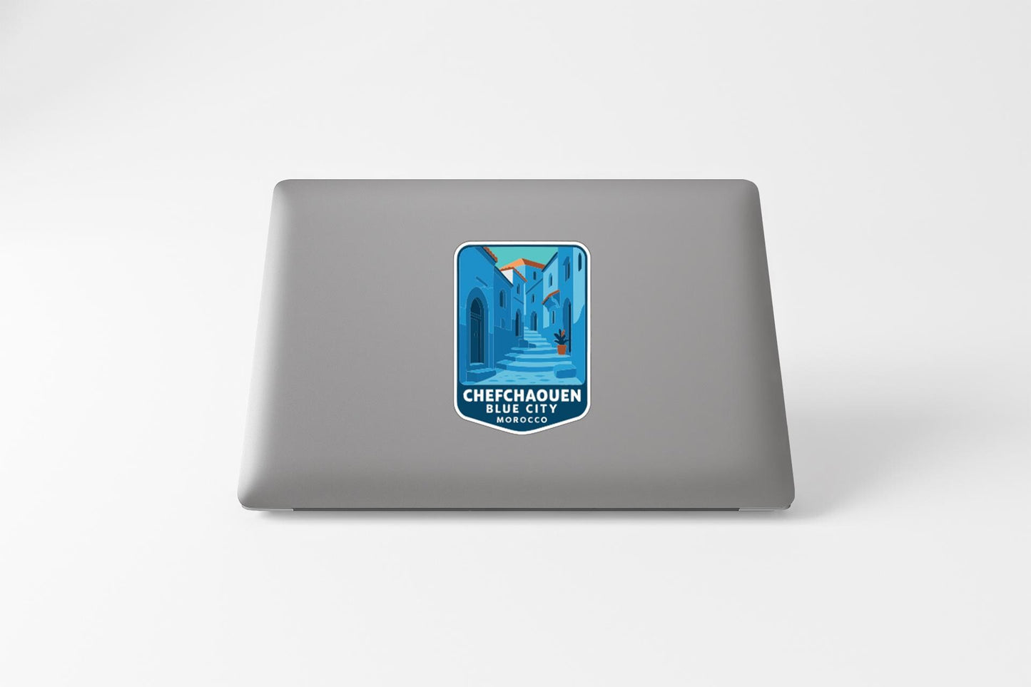 a sticker on the back of a laptop, depicting a cityscape with a mountain in the background.