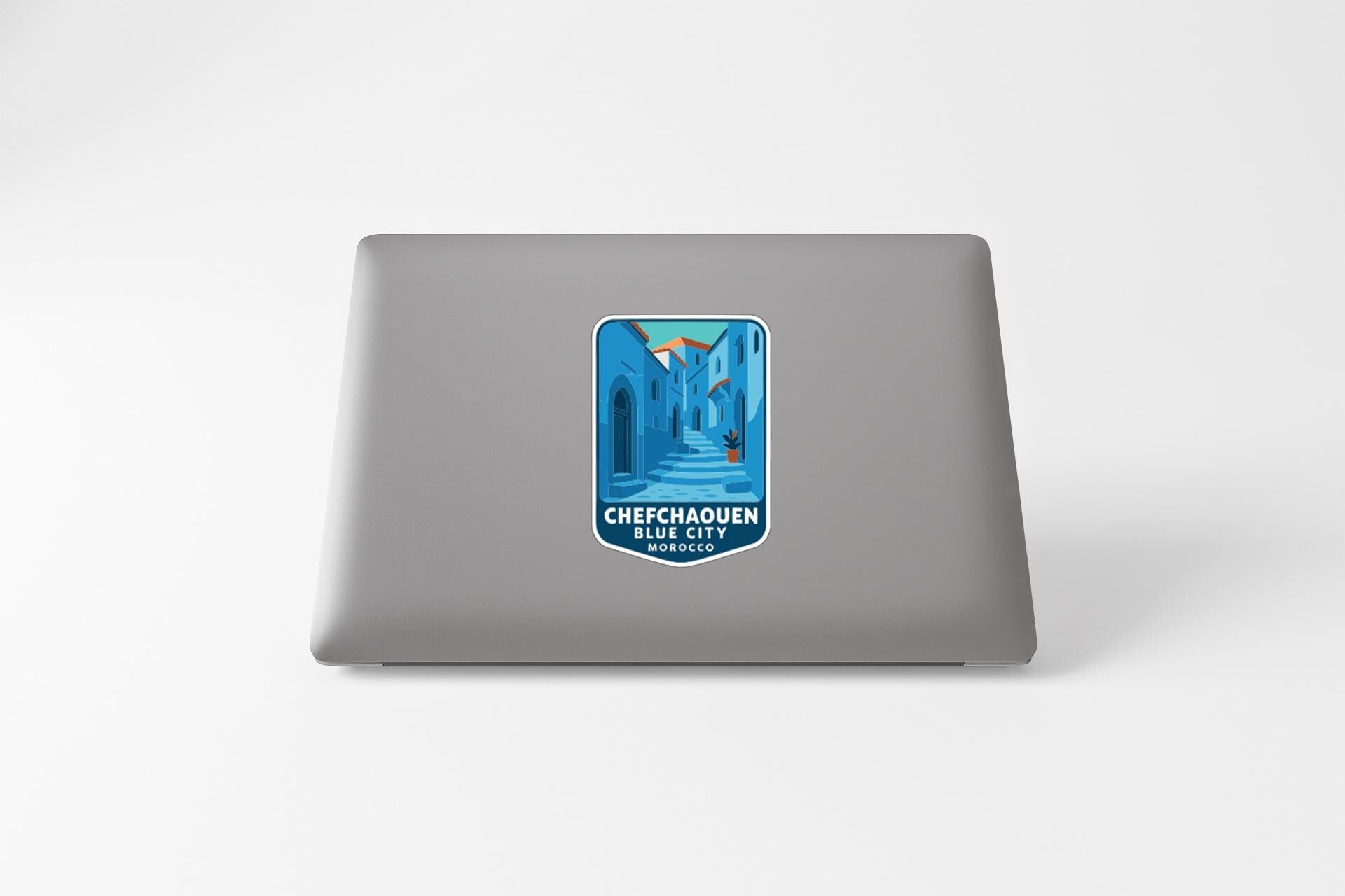 a sticker on the back of a laptop, depicting a cityscape with a mountain in the background.