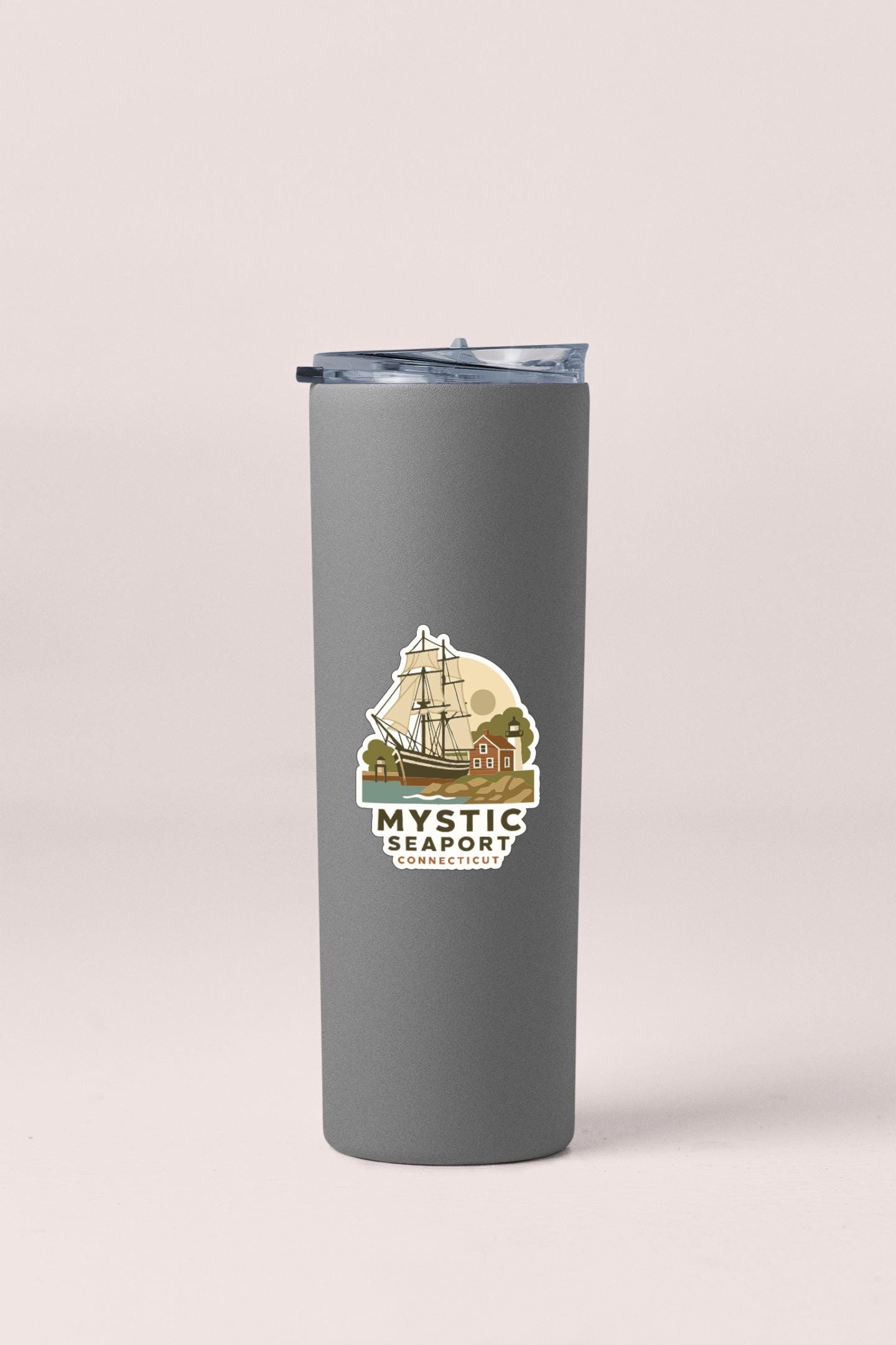 A gray insulated tumbler with a lid and a logo depicting a sailboat and a coastal scene.