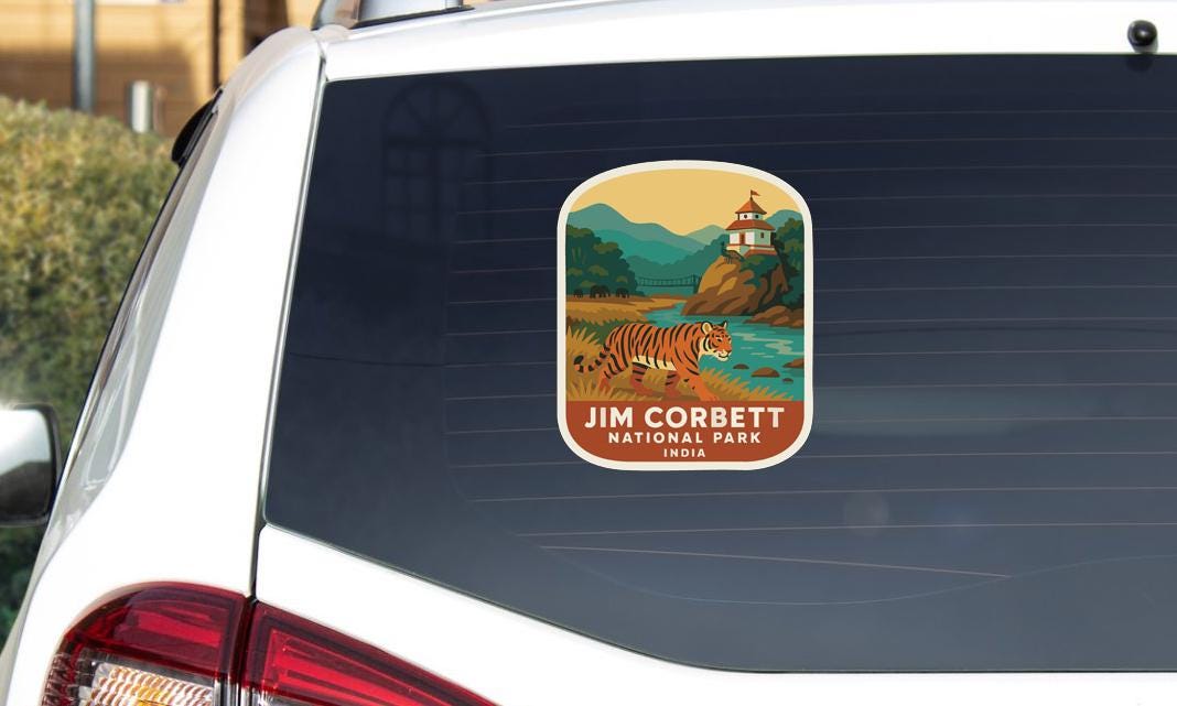 A sticker on the rear window of a car, depicting a tiger in a natural landscape with mountains in the background.