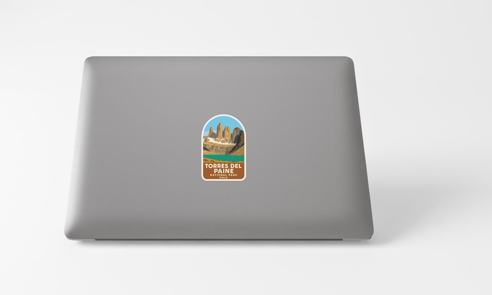 A sticker with a mountain landscape on a laptop.