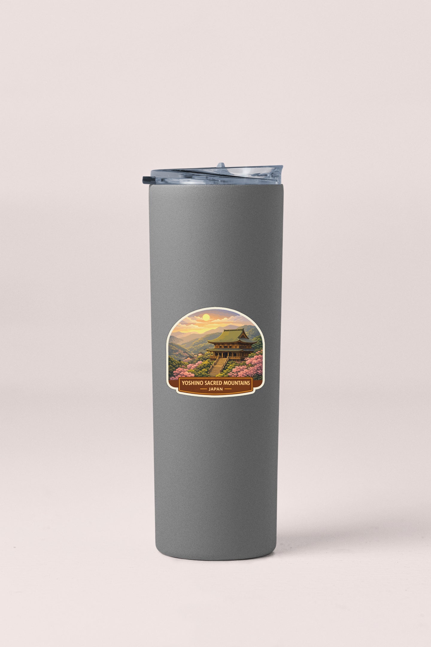 A gray insulated tumbler with a label featuring a scenic landscape and text.