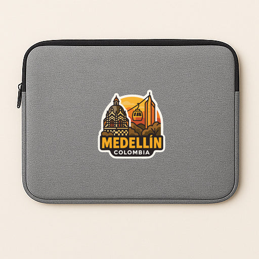 A gray laptop sleeve with a sticker depicting the city of Medellín, Colombia.