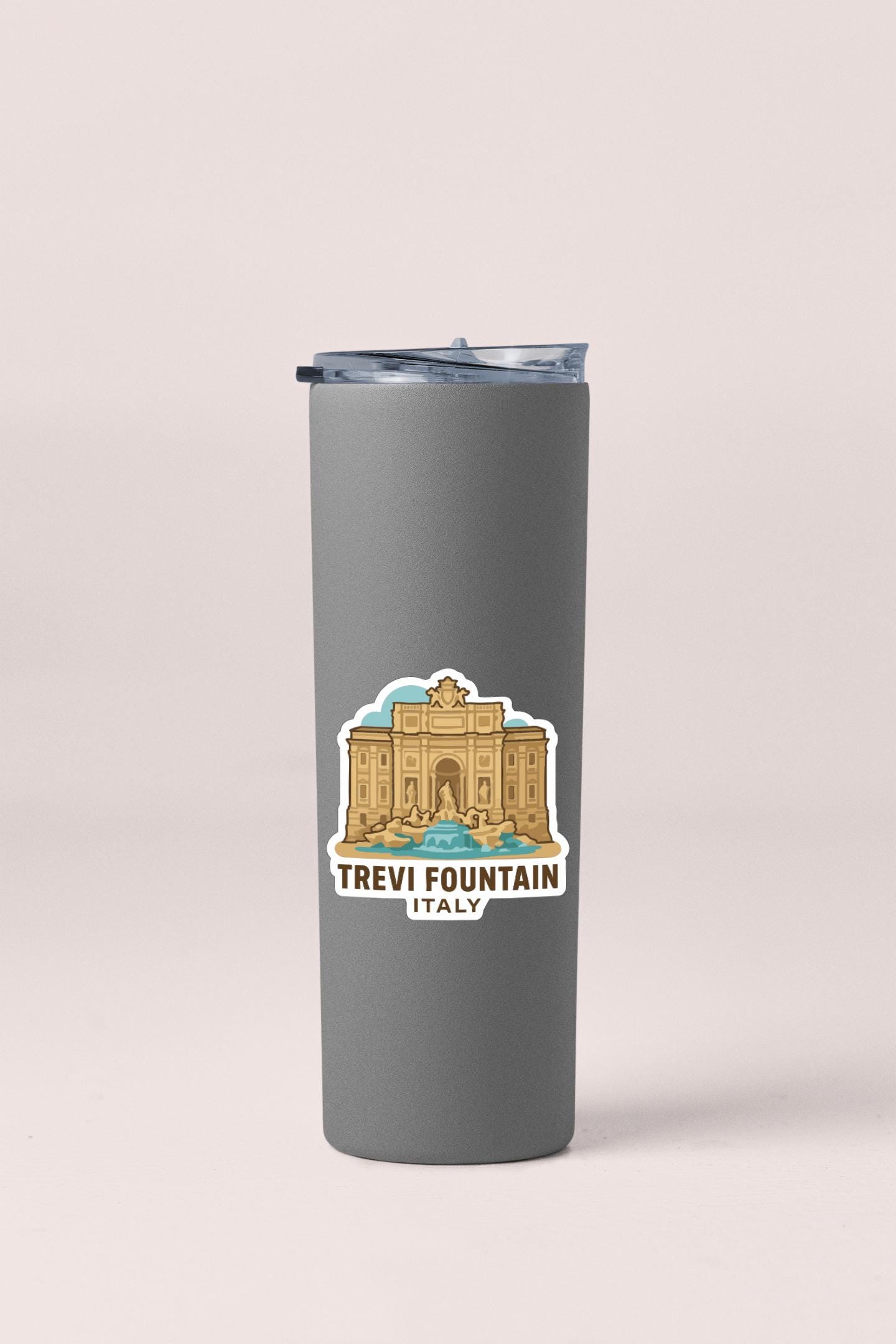 A gray insulated tumbler with a sticker depicting the Trevi Fountain in Italy.