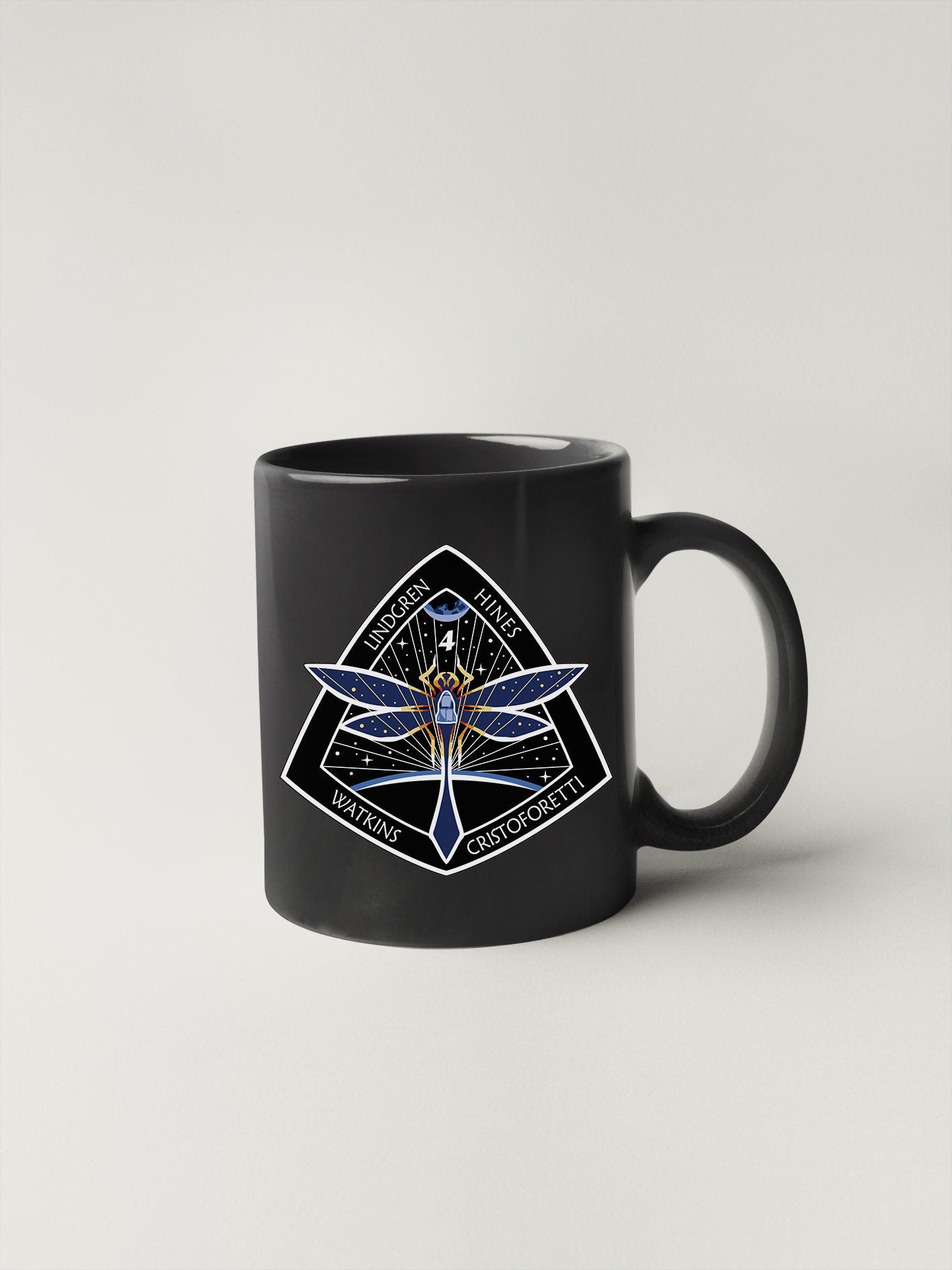a black coffee mug with a picture of a dragon on it