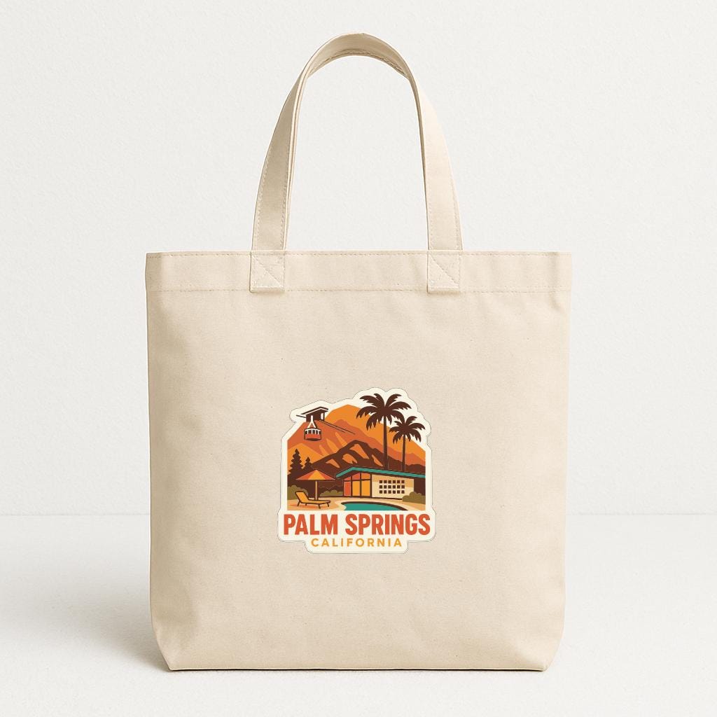 A beige tote bag with a printed design depicting a scenic view of Palm Springs, California.