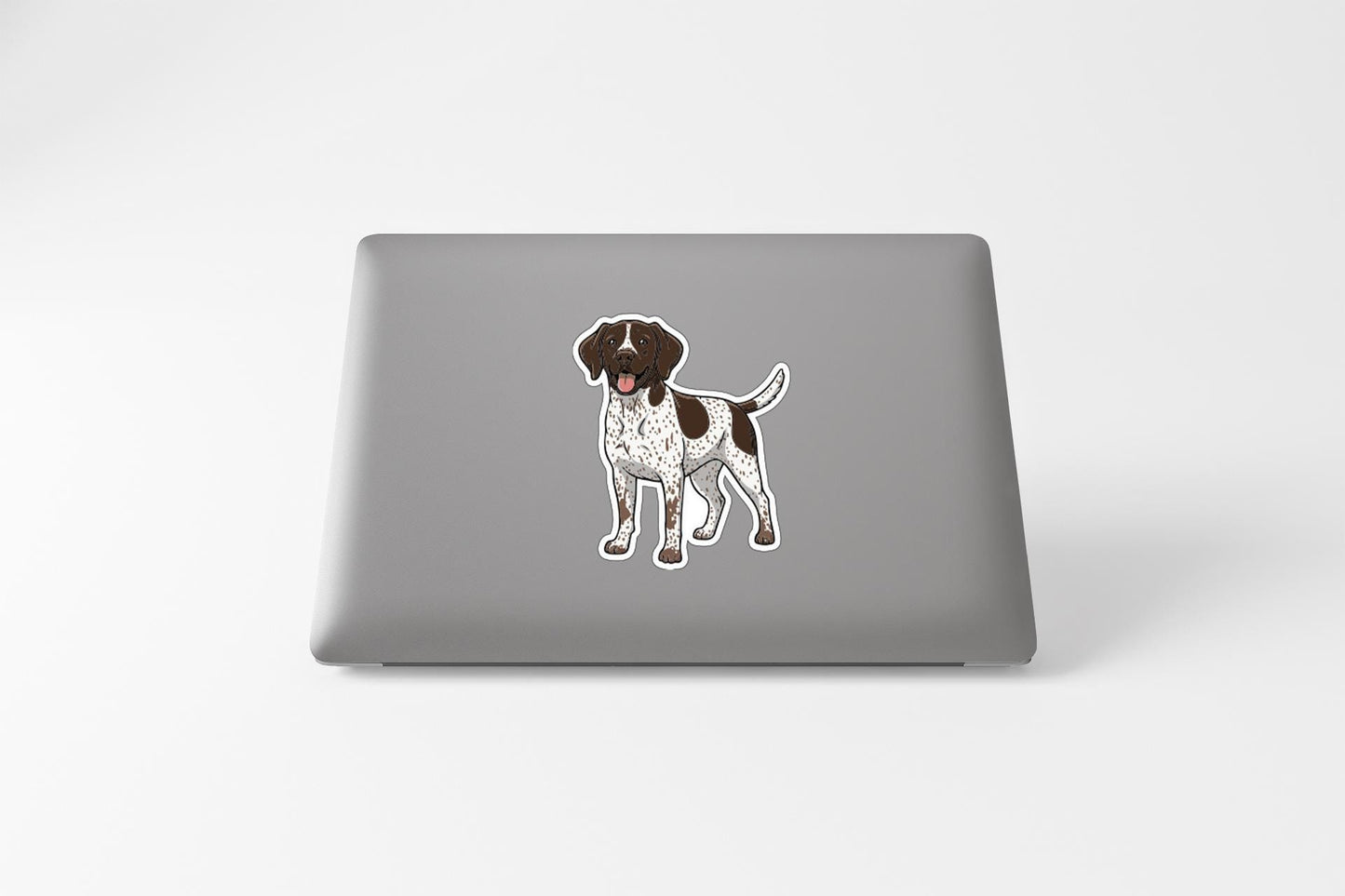 A sticker of a dog is placed on the back of a laptop.