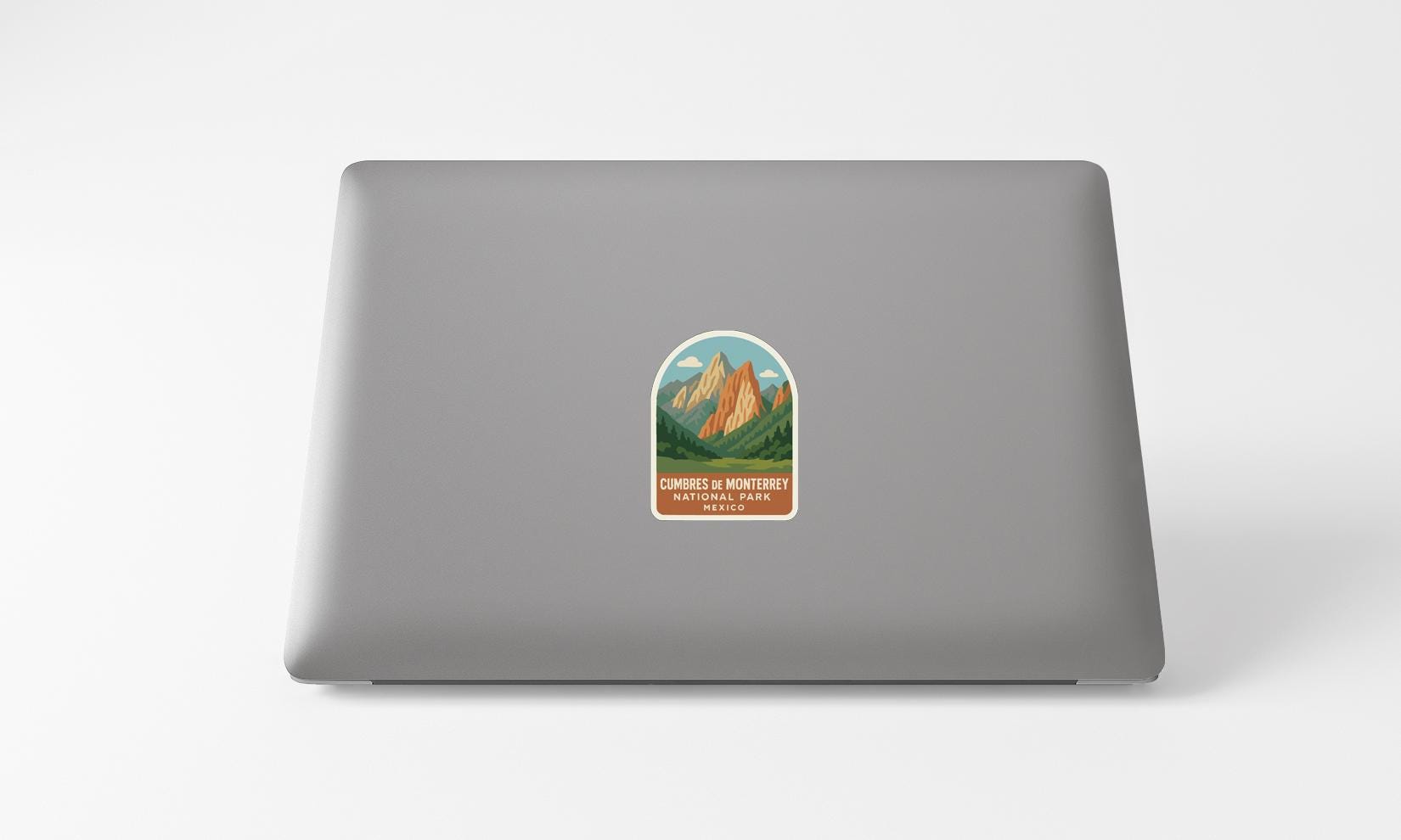 A sticker with a mountain landscape on a laptop.
