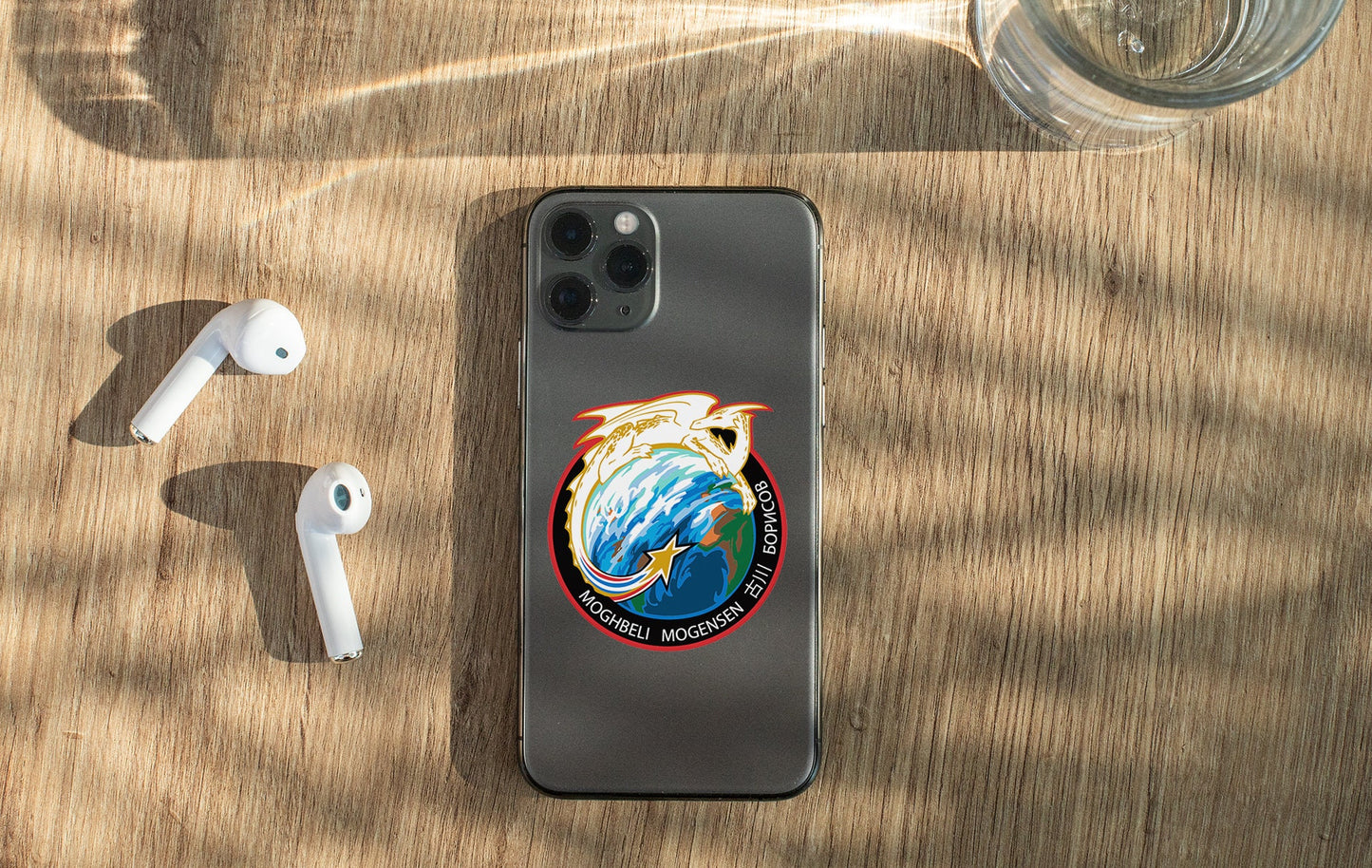 a phone with a sticker on it next to ear buds