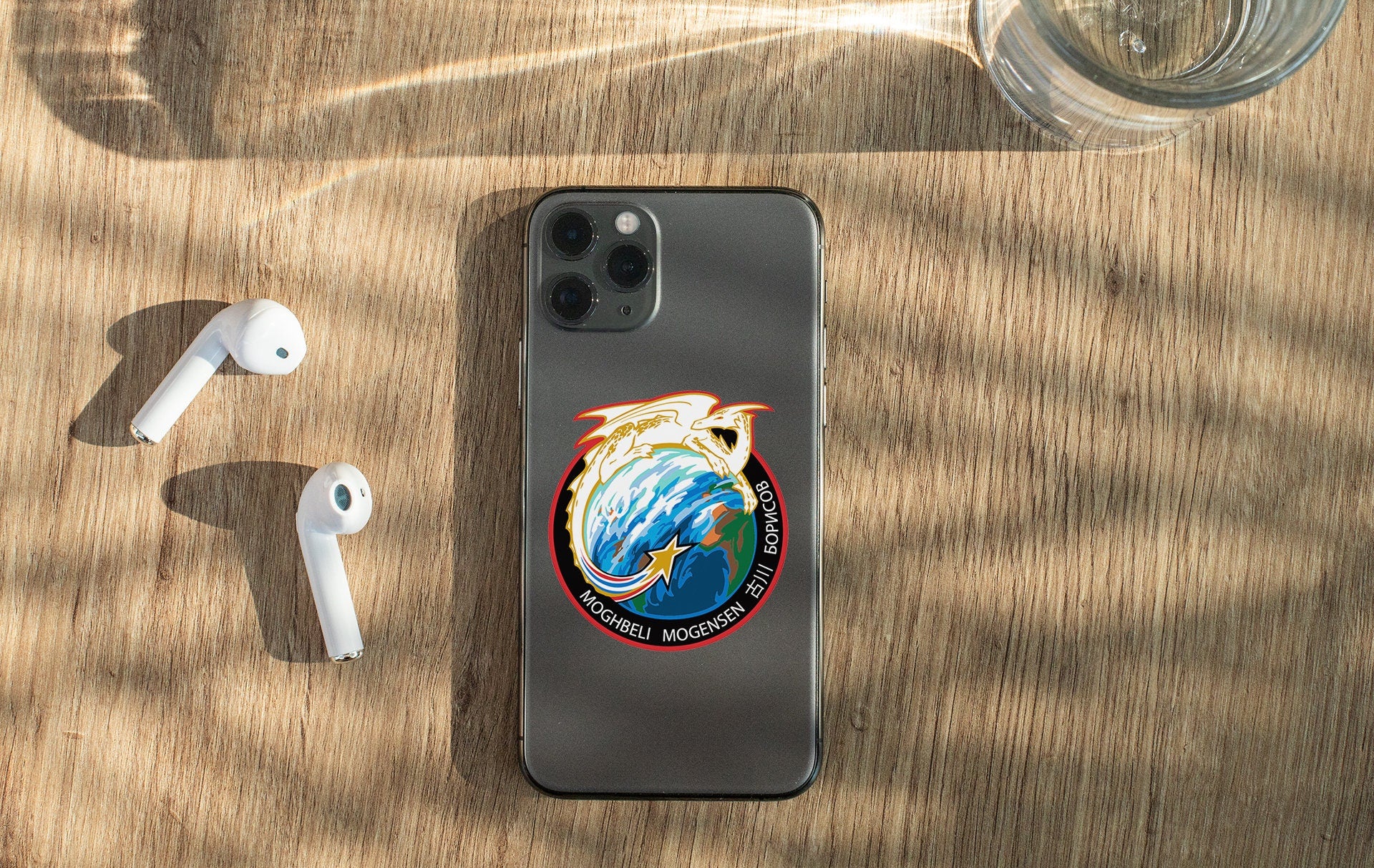 a phone with a sticker on it next to ear buds