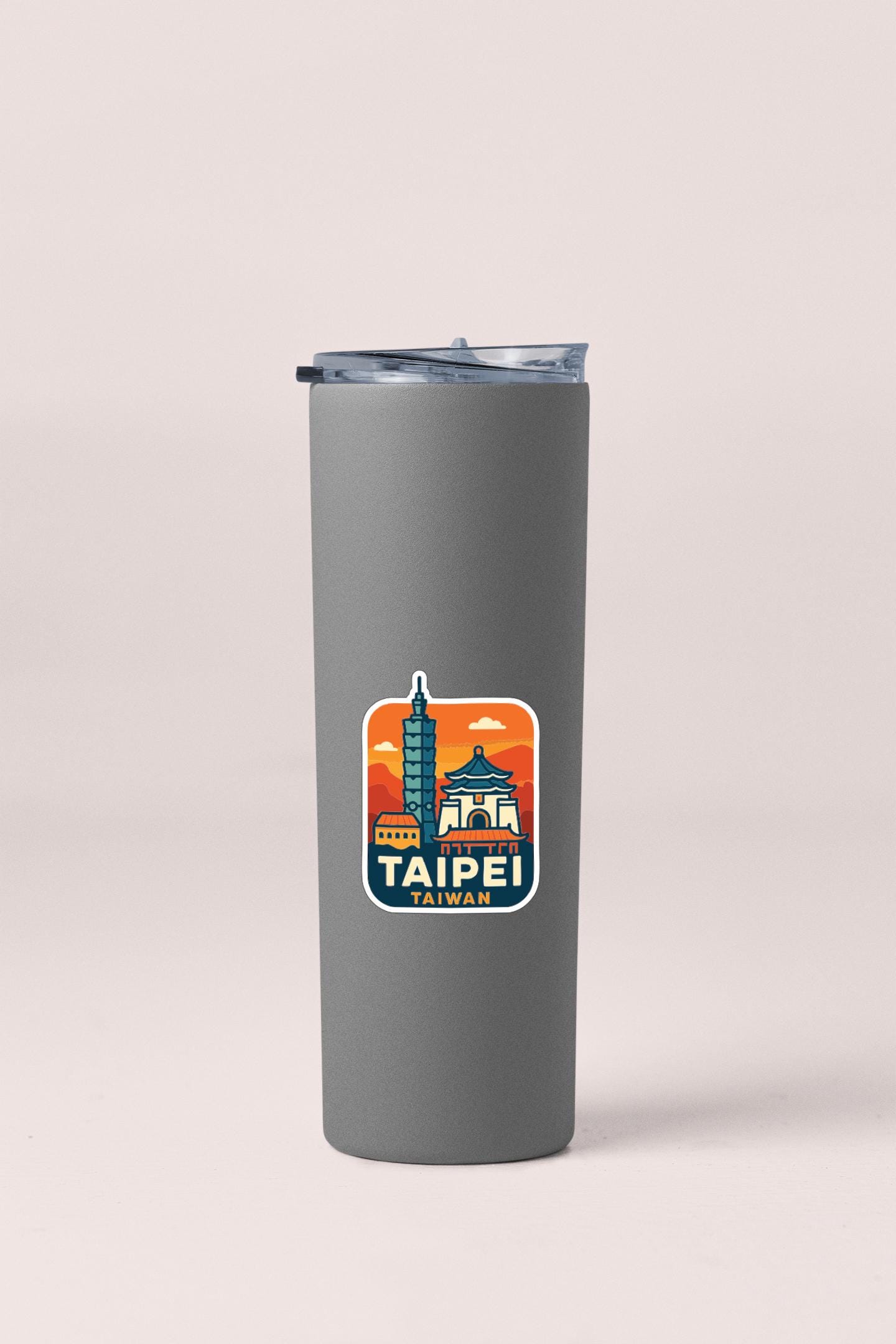 A gray insulated tumbler with a sticker depicting the skyline of Taipei, Taiwan.