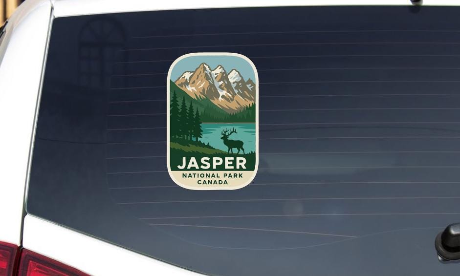 A sticker on the rear window of a vehicle, depicting a scenic landscape with mountains, a lake, and a deer.