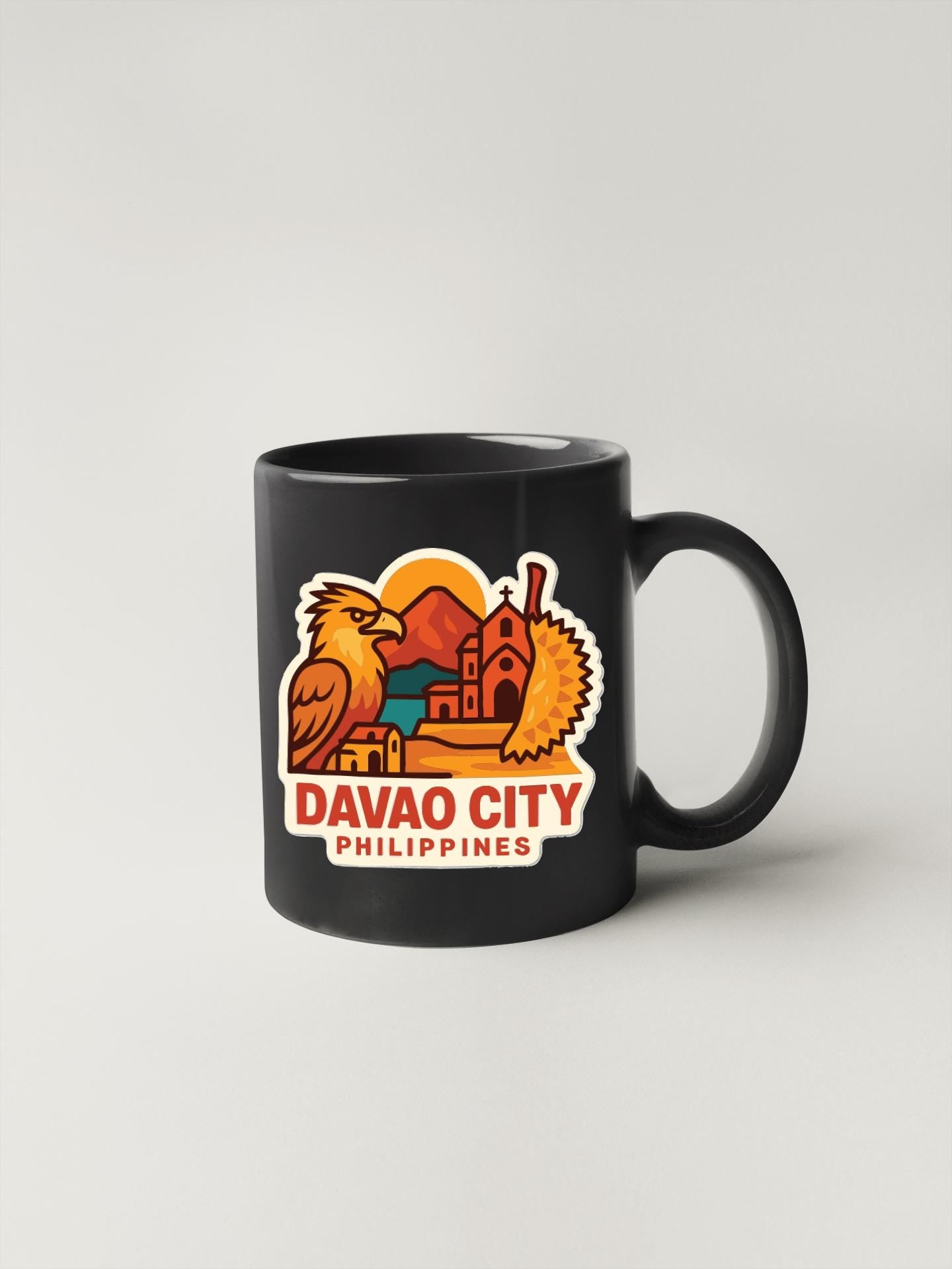 A black coffee mug with a colorful graphic depicting a city skyline and a bird, along with the text "DAVAO CITY PHILIPPINES".
