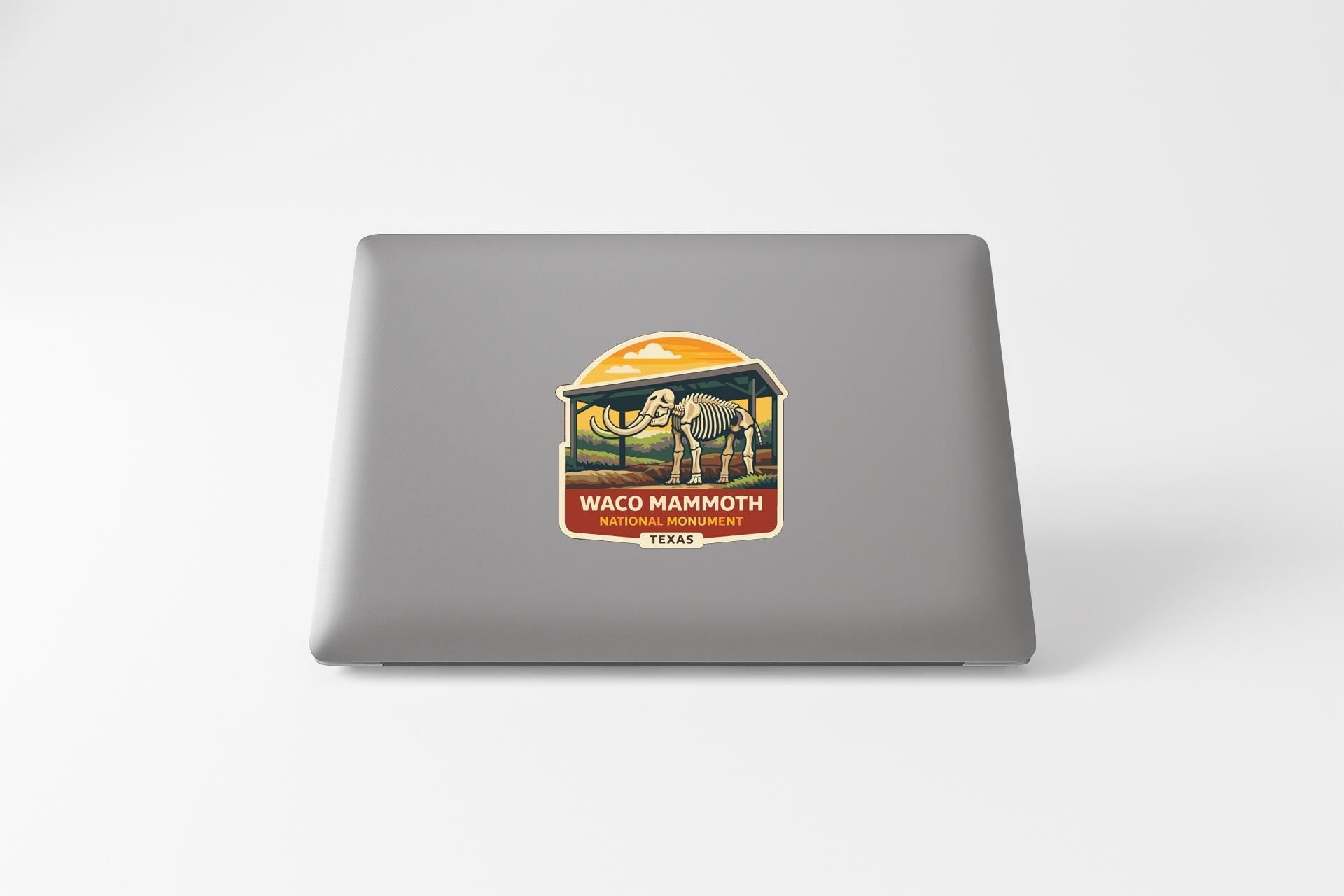 a sticker or decal on the back of a laptop, depicting an elephant and the text "WACOM MAMMOTH TEXAS".