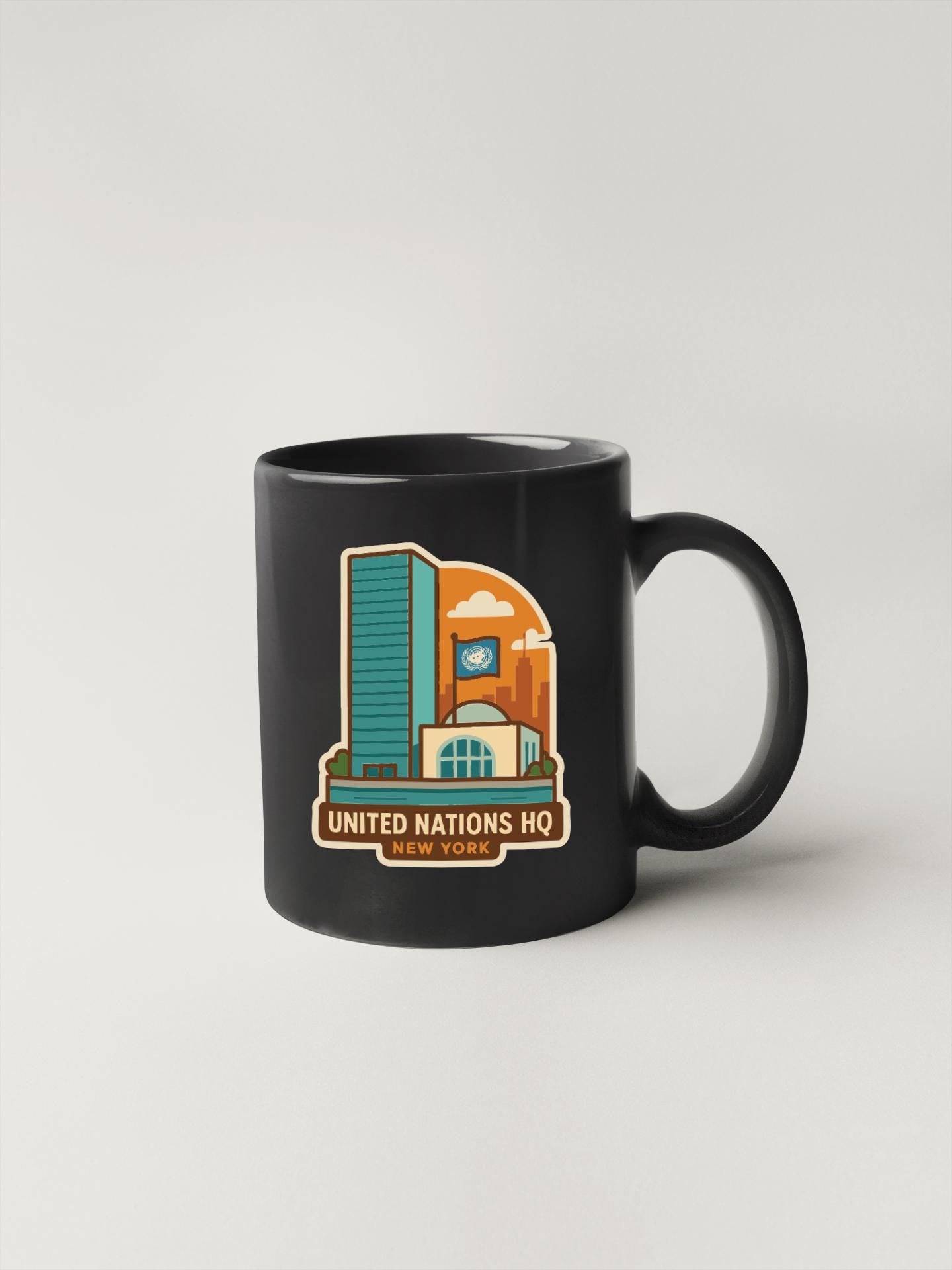 A black coffee mug with a graphic design depicting the United Nations Headquarters in New York.