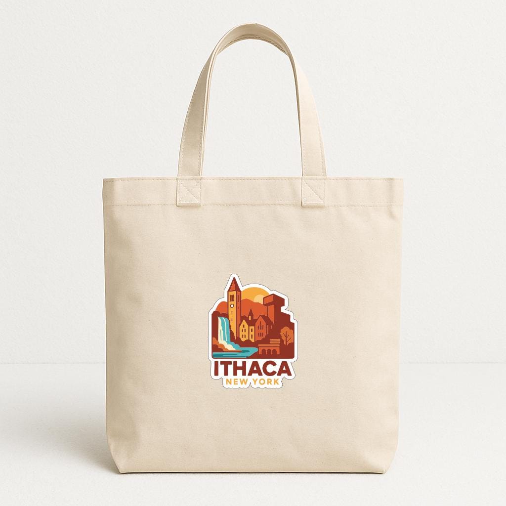 A beige tote bag with a printed design depicting a cityscape and the text "Ithaca New York" printed on it.