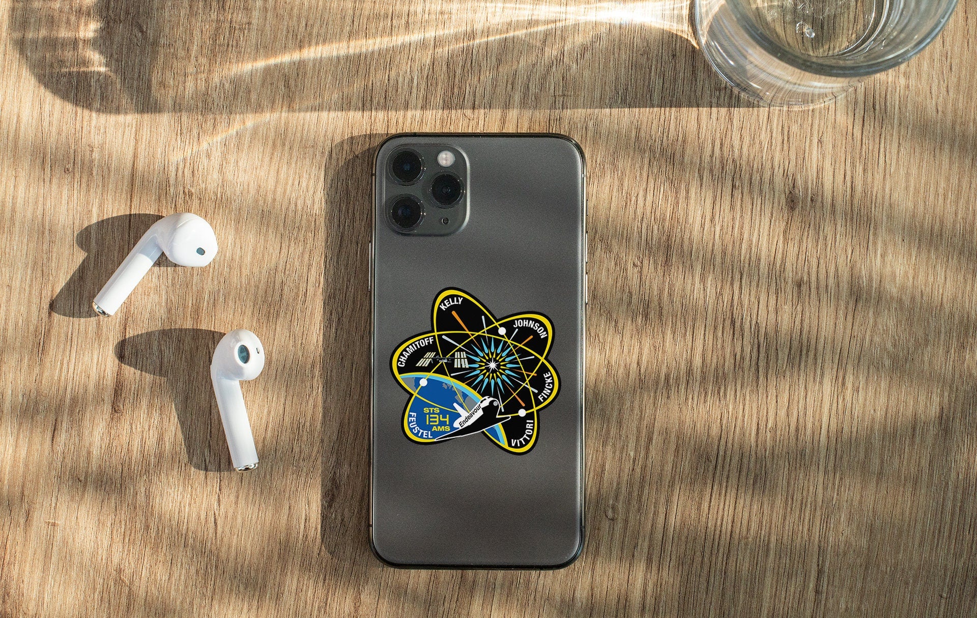 a phone with a sticker on it next to ear buds