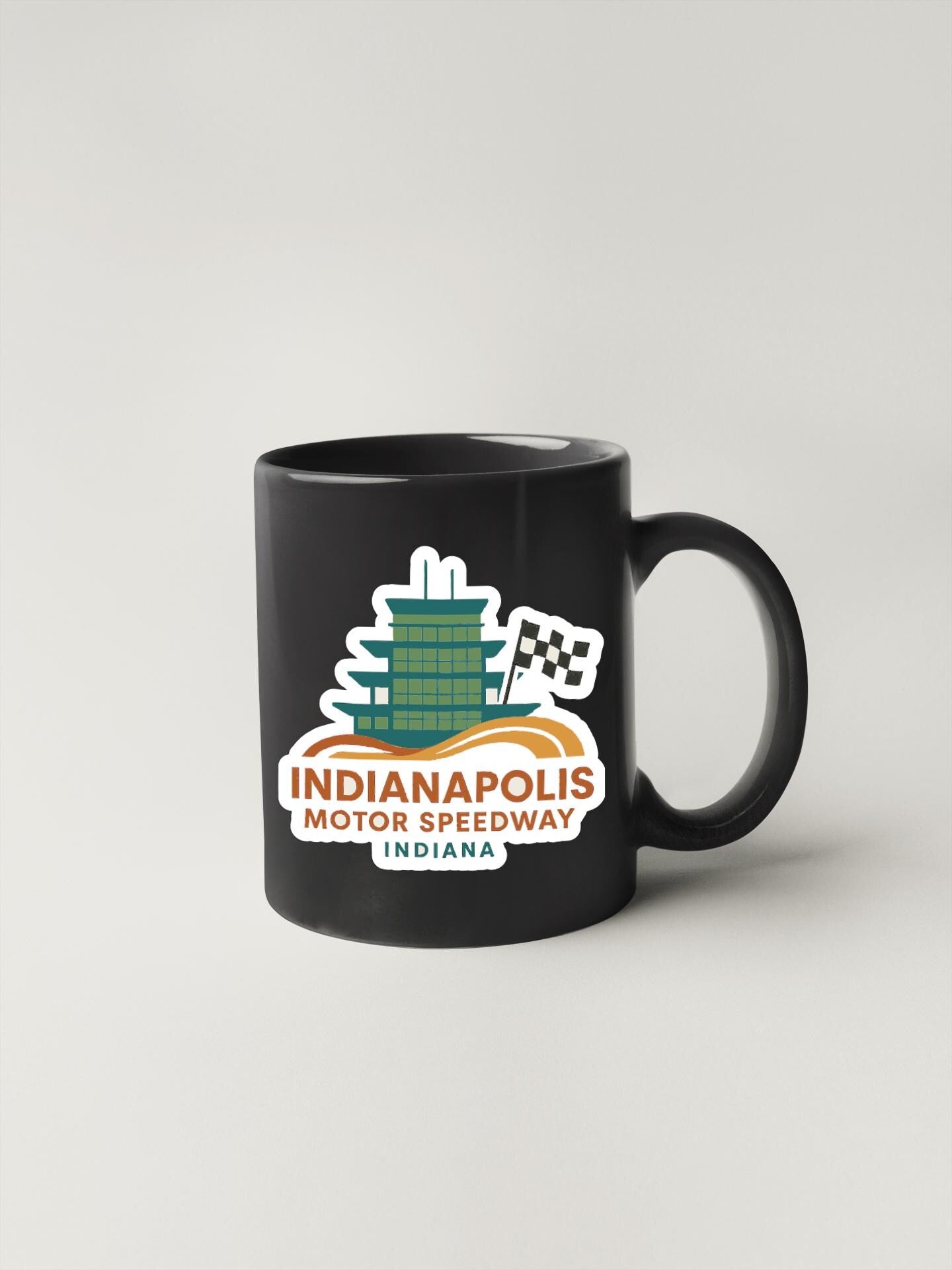 A black coffee mug with a logo for Indianapolis Motor Speedway, a racing track in Indiana.
