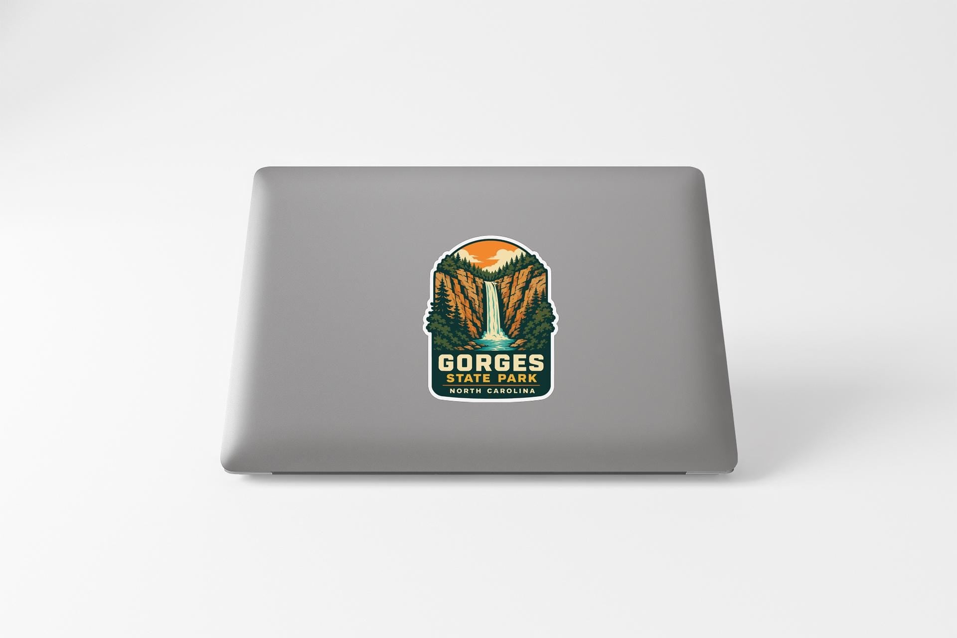 a sticker on the back of a laptop that displays the name "Gorges State Park" along with a scenic illustration of a waterfall and forest.