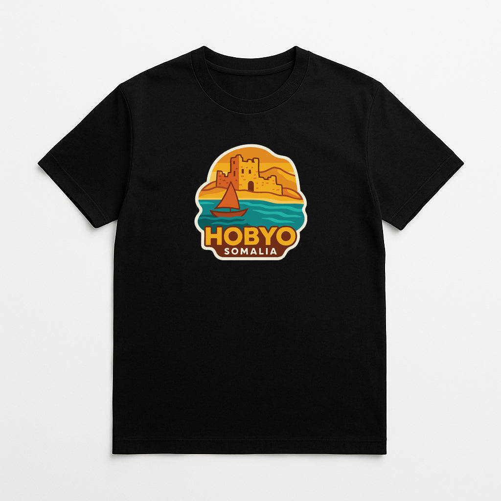 A black t-shirt with a graphic design depicting a castle, a sailboat, and a sunset over a body of water.