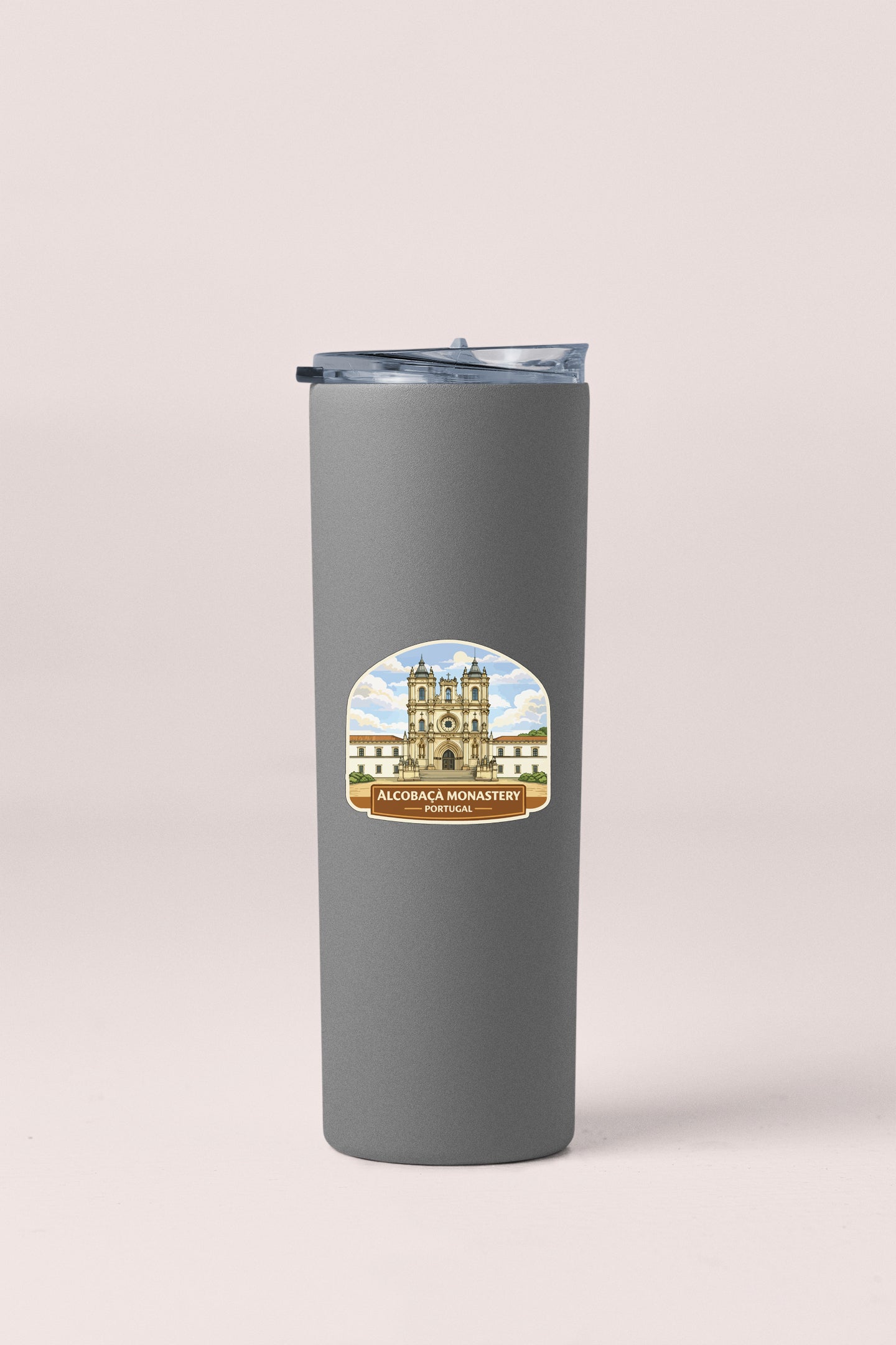 A gray insulated tumbler with a label featuring an illustration of a building and the text "ALCOHACIA MONASTERY" printed on it.