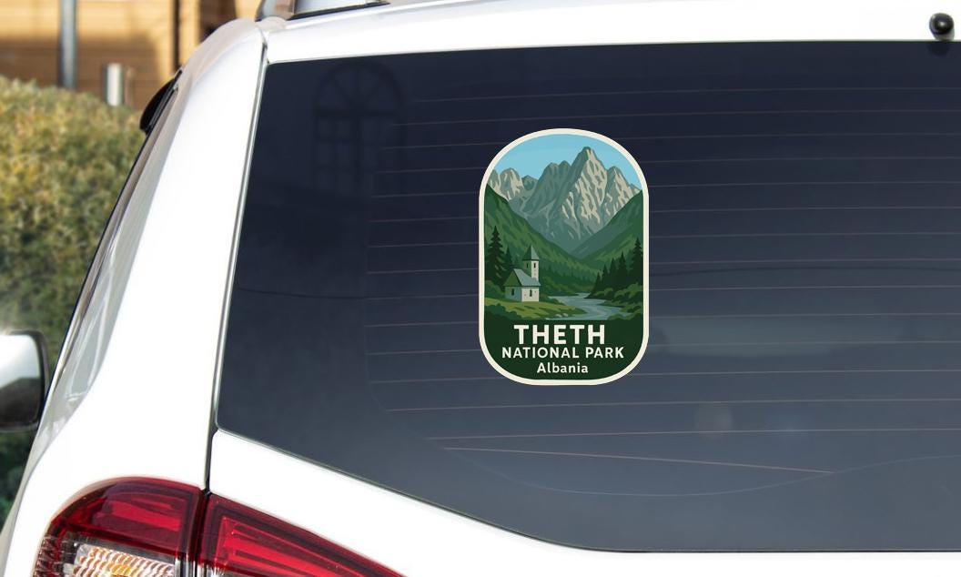 A sticker on the rear window of a car that says "Theth National Park, Albania".