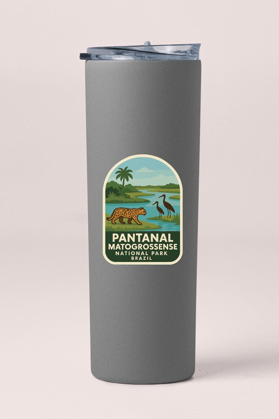A gray cylindrical container with a label that features an illustration of a pantan, a bird, and a landscape with a river.