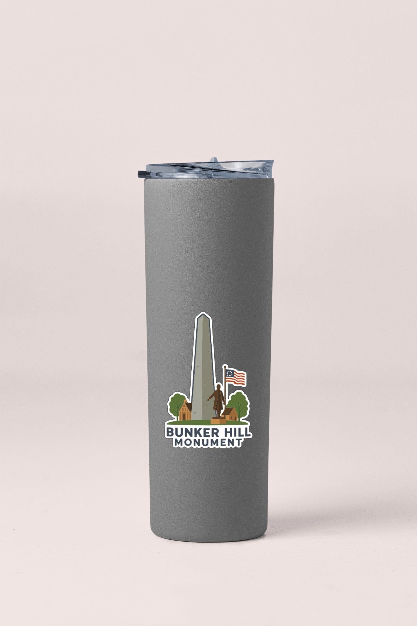 A gray tumbler with a sticker depicting the Bunker Hill Monument.
