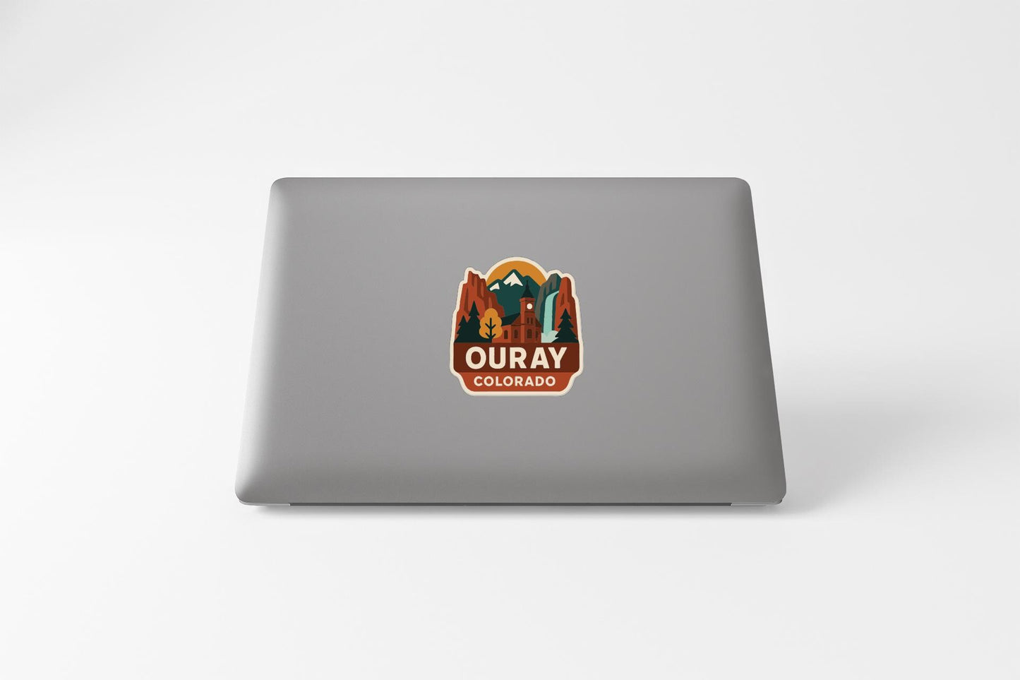 a sticker with a mountain and the text "Ouray, Colorado" on the back of a laptop.