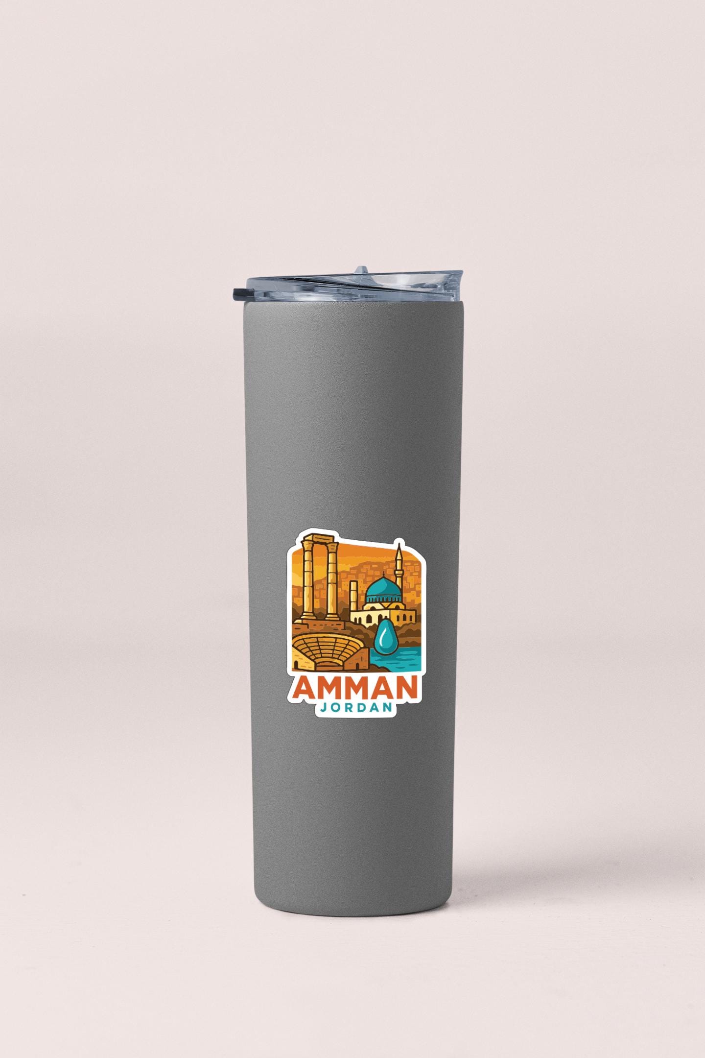 A gray insulated tumbler with a sticker depicting a cityscape and the text "AMMAN JORDAN" printed on it.