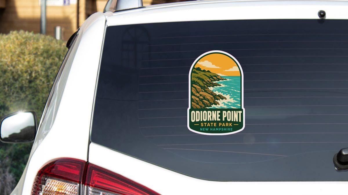 A sticker on the rear window of a white car, depicting a scenic landscape with mountains, water, and a sunset.