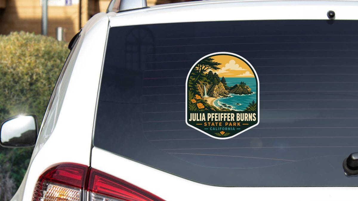 A sticker on the rear window of a white car, depicting a scenic landscape with mountains, trees, and a body of water.