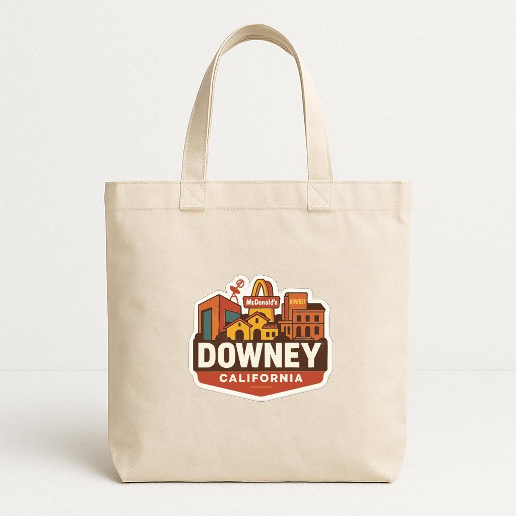 A beige tote bag with a McDonald's logo and the text "DOWNEY, CALIFORNIA" printed on it.