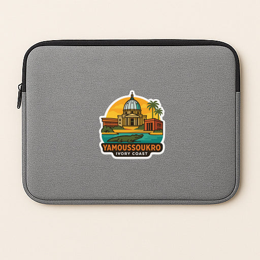 A gray laptop sleeve with a sticker depicting a landmark, likely Yamboussoukro Ivory Coast, on it.