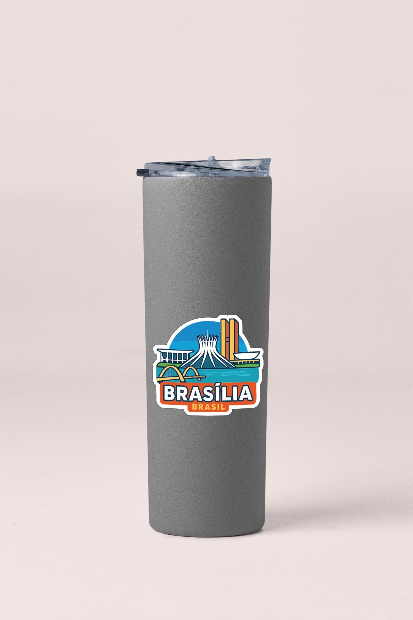 A gray insulated tumbler with a sticker depicting the city of Brasilia, Brazil.
